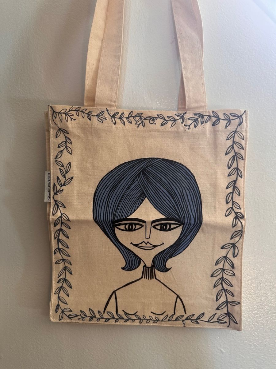 Painted canvas bag with image of a woman's face and hair